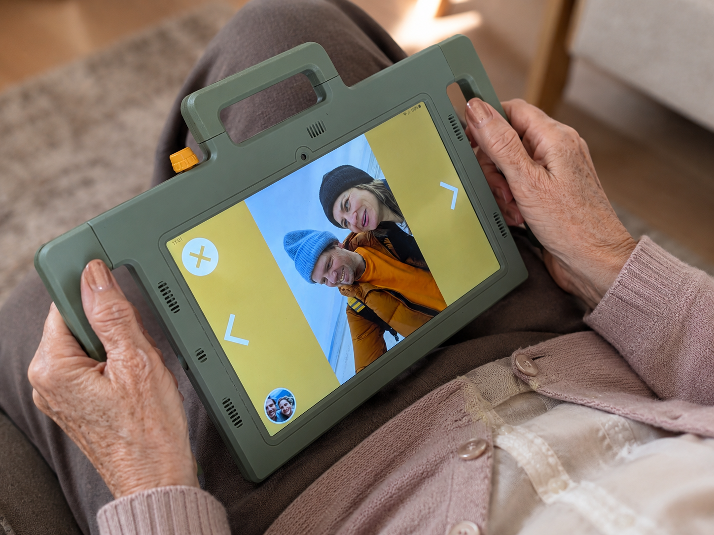 Seniorin hält Telemarie mit Videotelefonie und Fotoalbum in den Händen